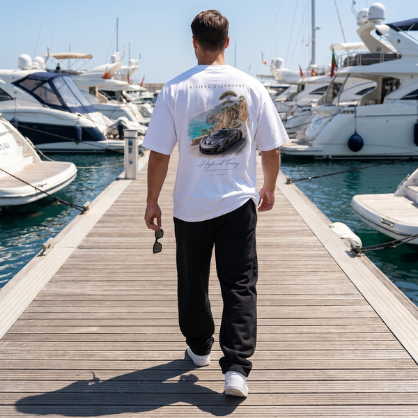 Homme portant le t-shirt blanc Riviera Overboost McLaren P1 sur un ponton de marina entre yachts