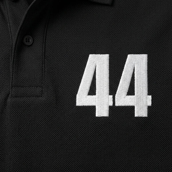 Gros plan sur le 44 brodé en blanc du polo noir Lewis Hamilton