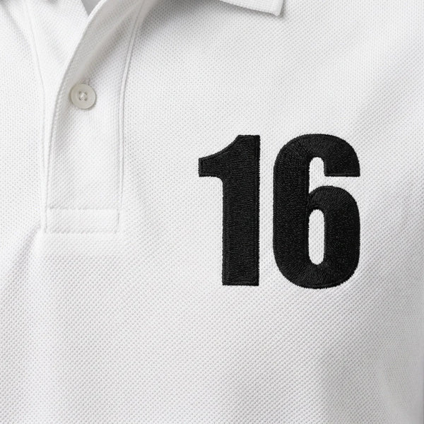 Gros plan sur le 16 brodé en noir du polo blanc Charles Leclerc