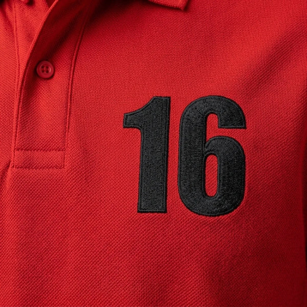Gros plan sur le 16 brodé en noir du polo rouge Charles Leclerc