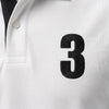 Gros plan sur le 3 brodé en noir du polo blanc Max Verstappen
