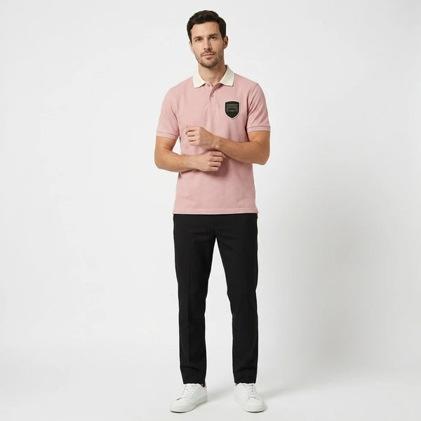 Homme portant le polo Porsche GT3 RS rose, vu de face en pied