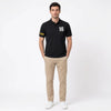 Homme portant le polo noir Charles Leclerc, vu de face en pied