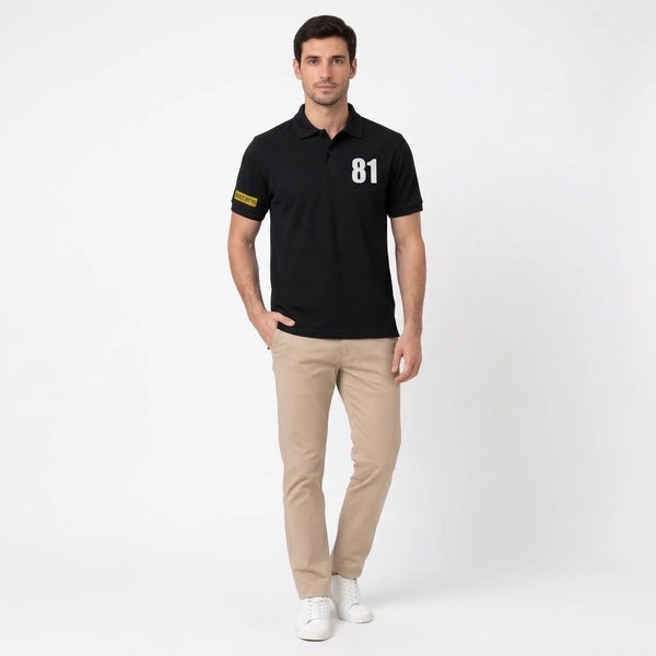 Homme portant le polo noir Oscar Piastri, vu de face en pied