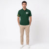 Homme portant le polo vert bouteille Oscar Piastri, vu de face en pied
