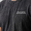 Close-up of the Tourismo logo on the chest of the washed T-shirt