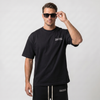 Homme portant le t-shirt noir Tourismo Clothing avec lunettes de soleil, logo poitrine blanc